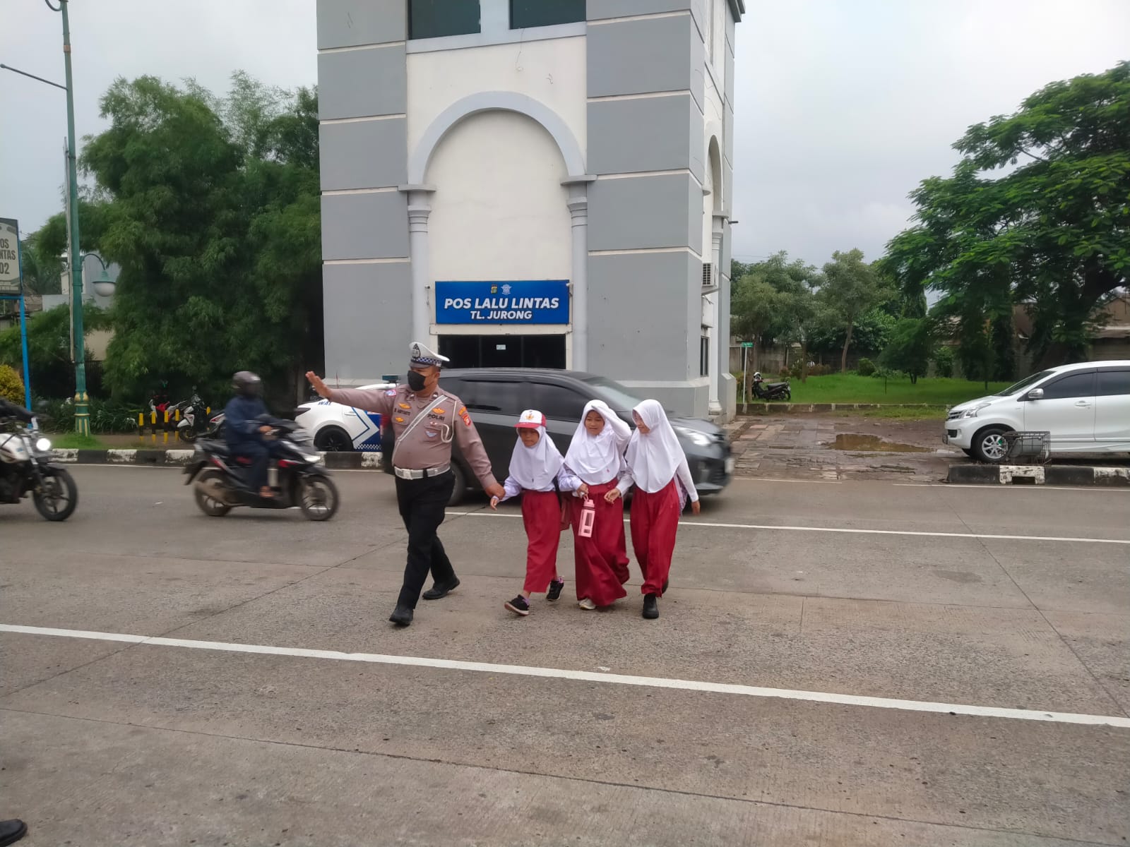 Tak Hanya Melaksanakan Pengaturan Lalulintas, Anggota Satlantas Polres Metro Bekasi Sigap Sebrangkan Pelajar Hendak Berangkat Sekolah